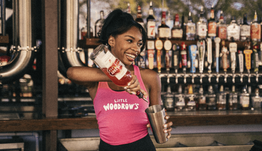 http://bartender%20smiling%20as%20she%20pours%20liquor%20into%20a%20shaker%20to%20a%20make%20a%20cocktail