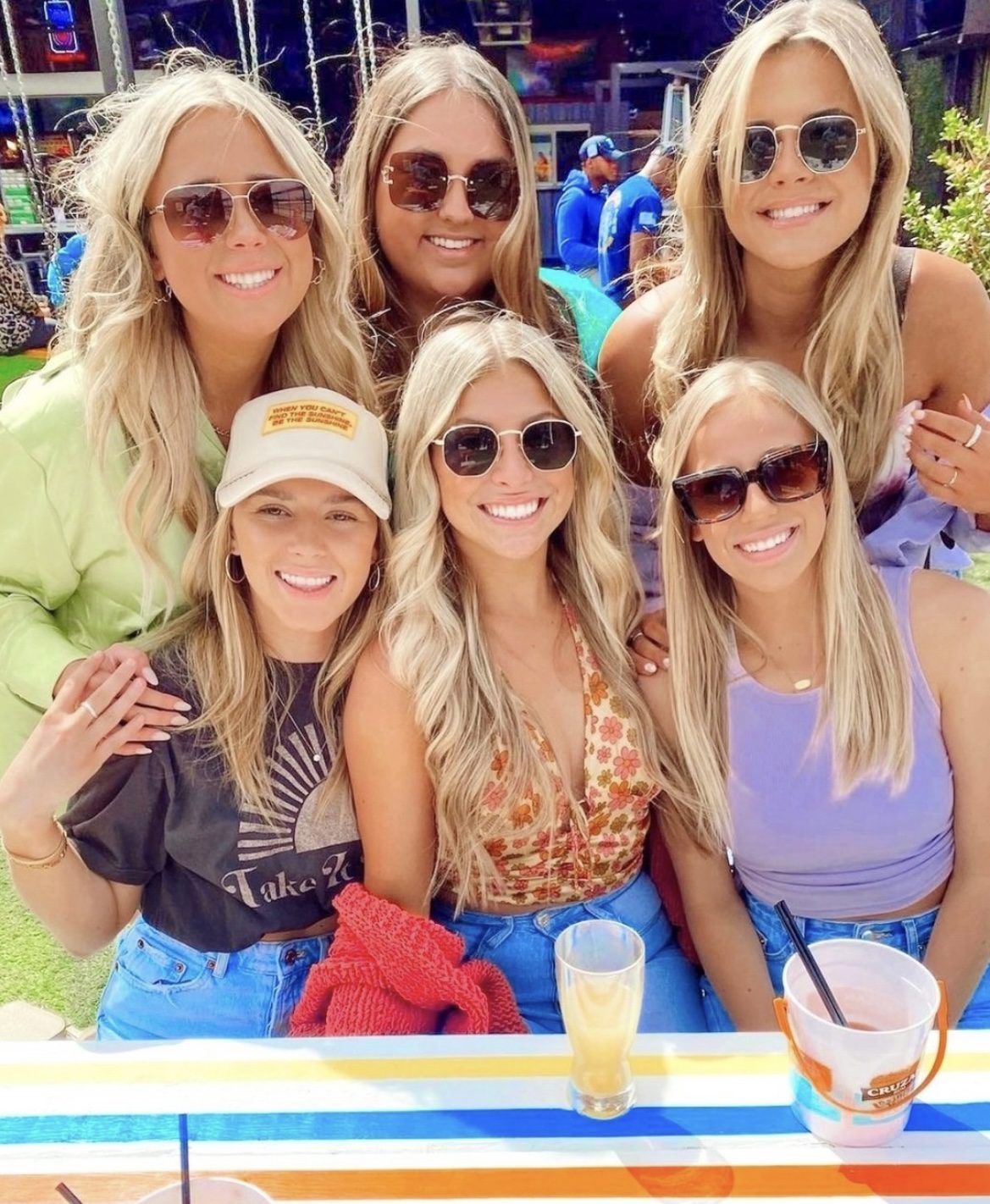 group of blonde women with sunglasses posing at outside bar